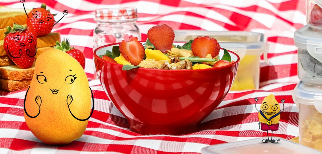 Cerealdo con una medalla junto a mango enamorado y bowl de ensalada con frutas.